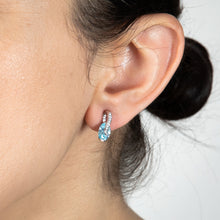 Load image into Gallery viewer, Sterling Silver Rhodium Plated Light Blue And White CZ Crossover Stud Earrings